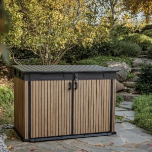 Szafa wielofunkcyjna Deco Horizontal 2020L Venetian Brown Keter w aranżacji ogrodowej na kamiennej ścieżce