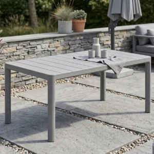 Stół ogrodowy SCANDI DINING Storm grey Keter ustawiony na tarasie z kamiennym murem w tle Stół ogrodowy SCANDI DINING Storm grey Keter ustawiony na tarasie z kamiennym murem w tle