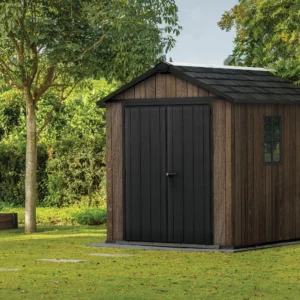 Domek narzędziowy Keter DECO APEX 759/975 orzechowy z czarnymi drzwiami i oknami w otoczeniu zieleni Domek narzędziowy Keter DECO APEX 759/975 orzechowy z czarnymi drzwiami i oknami w otoczeniu zieleni