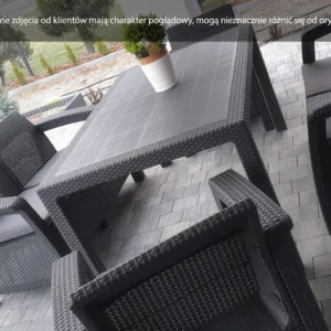 Zestaw ogrodowy CORFU FIESTA II Graphite: grafitowy prostokątny stół z technorattanu z czterema fotelami z poduszkami, ustawiony na kamiennym tarasie, ozdobiony donicą z rośliną. Zestaw ogrodowy CORFU FIESTA II Graphite: grafitowy prostokątny stół z technorattanu z czterema fotelami z poduszkami, ustawiony na kamiennym tarasie, ozdobiony donicą z rośliną.