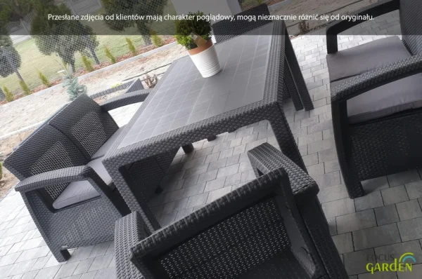 Zestaw ogrodowy CORFU FIESTA II Graphite: grafitowy prostokątny stół z technorattanu z czterema fotelami z poduszkami, ustawiony na kamiennym tarasie, ozdobiony donicą z rośliną. Zestaw ogrodowy CORFU FIESTA II Graphite: grafitowy prostokątny stół z technorattanu z czterema fotelami z poduszkami, ustawiony na kamiennym tarasie, ozdobiony donicą z rośliną.