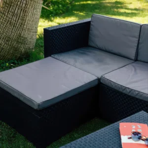 Widoczny podnóżek dostawiony do kanapy MANHATTAN - razem tworzą narożnik, w tle ogród